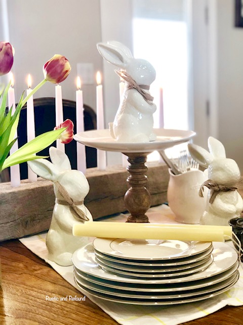 A DIY cake stand, white bunnies, white plates and wooden candle holder.1