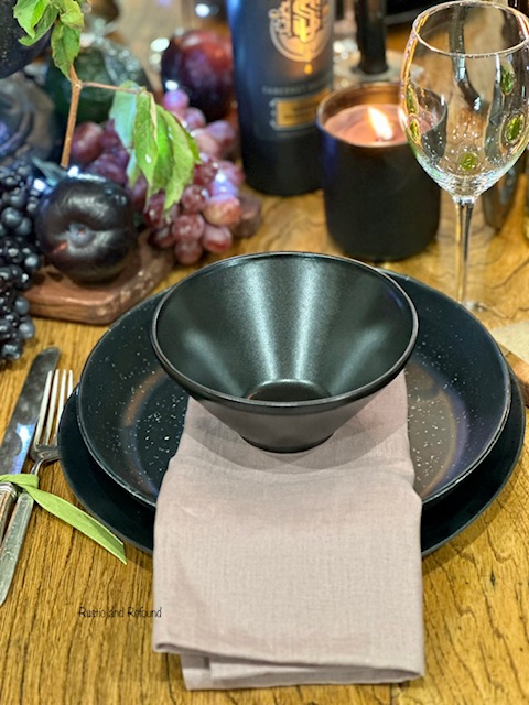 Collected black dinnerware with a purple napkin. 