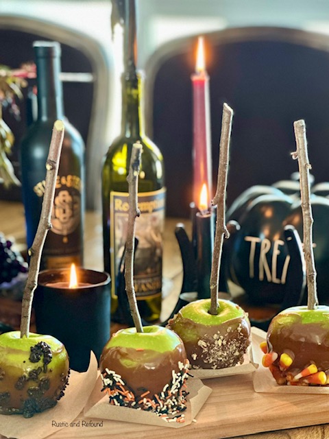 Caramel dipped apples displayed with black elements and candles.