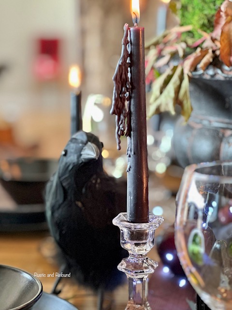 drippy black candle with raven on enchanted forest table