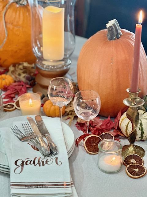 A Thanksgiving table with romantic inspiration with goblets and linens that say gather.