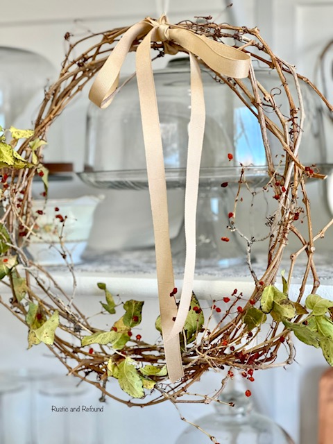 Foraged clippings in a grapevine wreath with a gold bow.