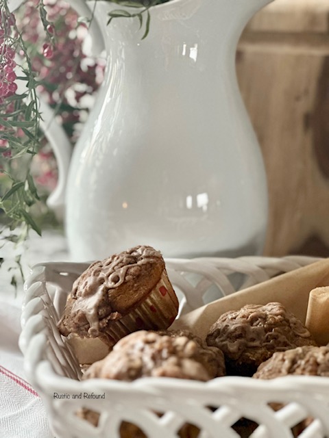 pumpkin muffins with a streusel topping in a white basket, white pitcher with red berries