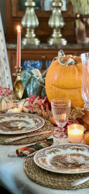 A Thanksgiving table with Royal Stafford pheasant plates, bold pumpkins, fall foliage, and candles. Serape napkins 1