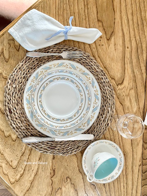 Collecting vintage dishes white plates with a gold rim, turquoise blue brushstroke design intertwined with golden leaves and vines in place setting.