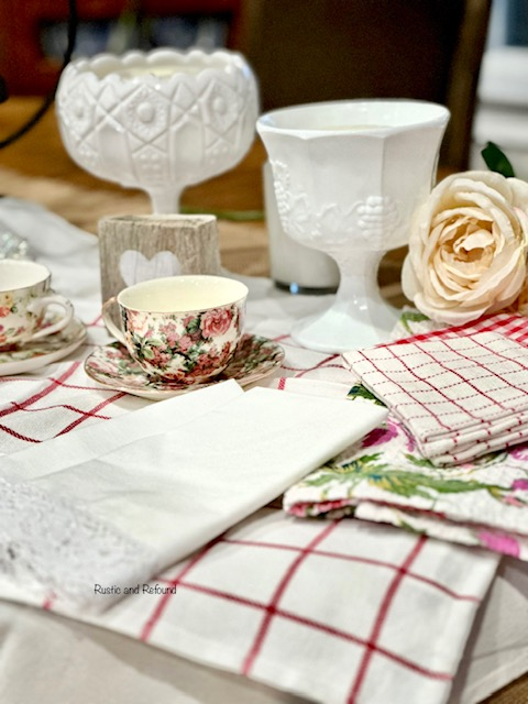 Red & white Linens, chintz tea cups, milk glass compotes, faux rose & Valentine's decor.