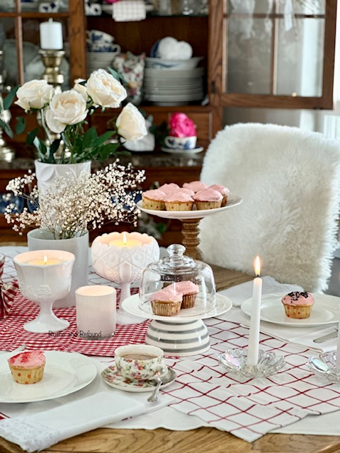 A simple and sweet Valentine' Day table for two with candles and pink cupcakes.