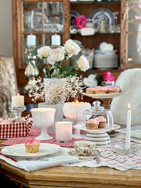A simple and sweet Valentine' Day table for two with cupcakes and flowers.